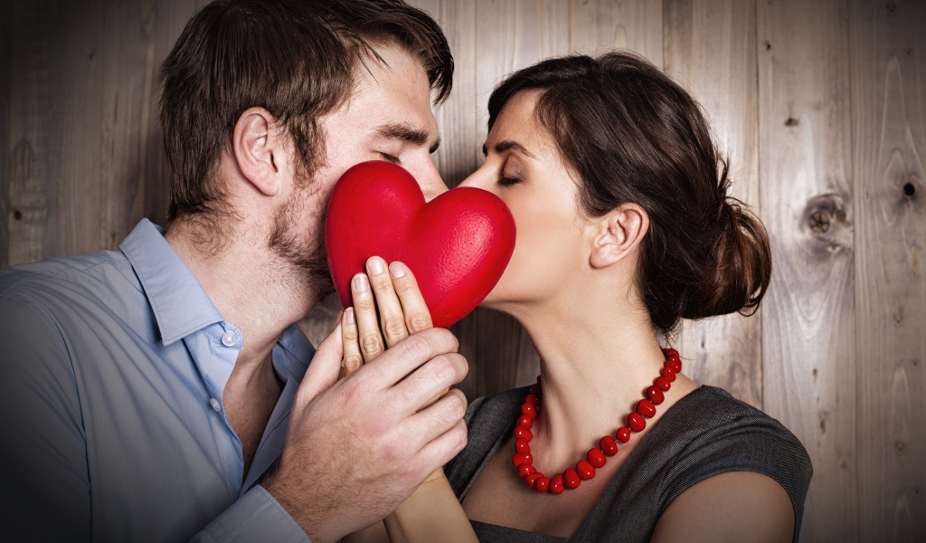 Поцелуй влюбленной пары за красным сердцем