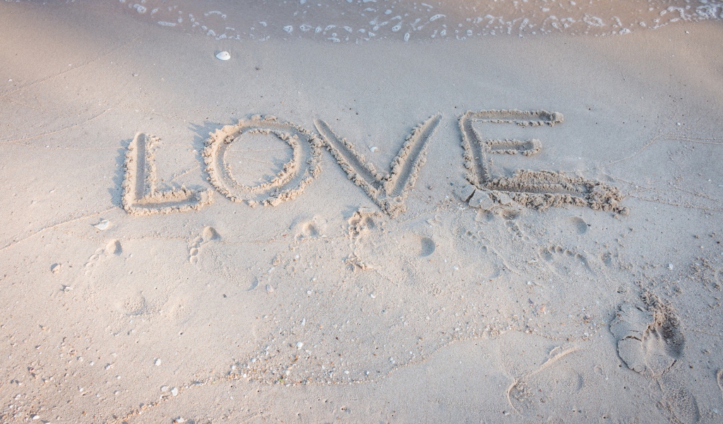 Надпись Любовь на мокром песке у моря