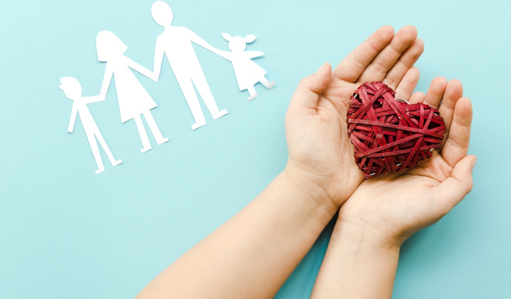 Плетеное сердце в руках на голубом фоне