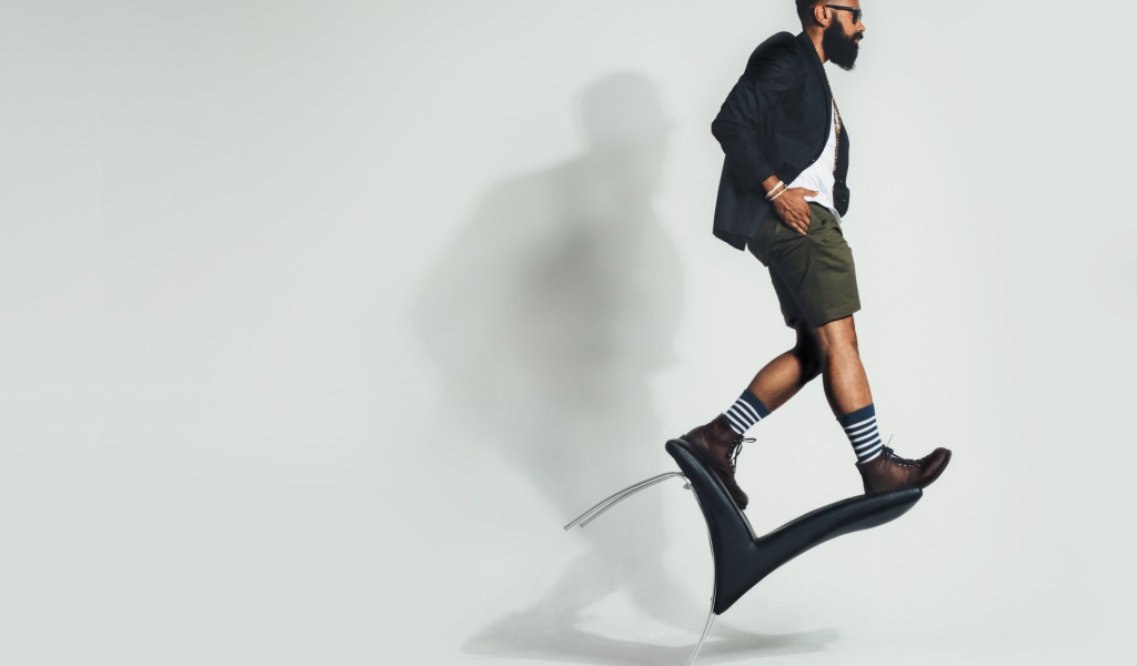 Мужчина балансирует на черном кресле