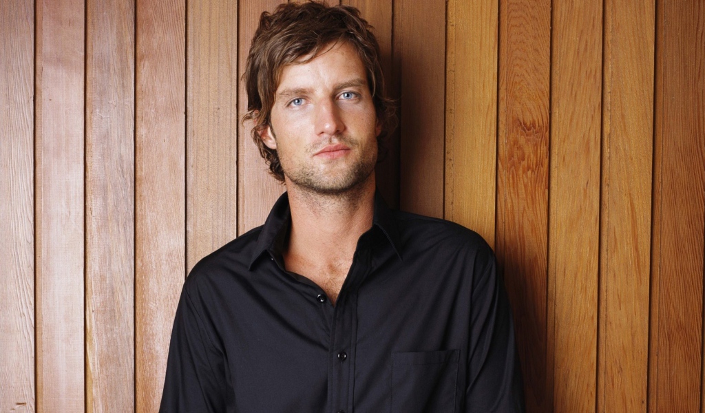 Handsome man in black shirt on wooden background