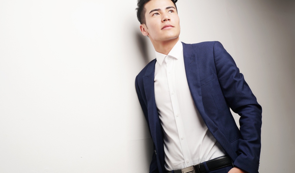 Мужчина модель в костюме у белой стены