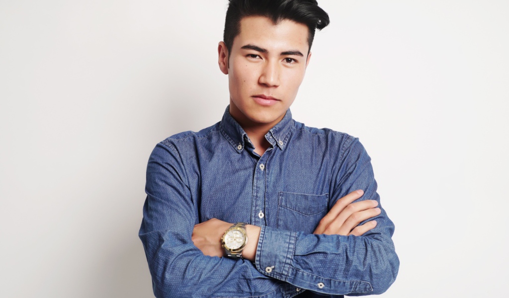 Мужчина в синей рубашке на сером фоне 