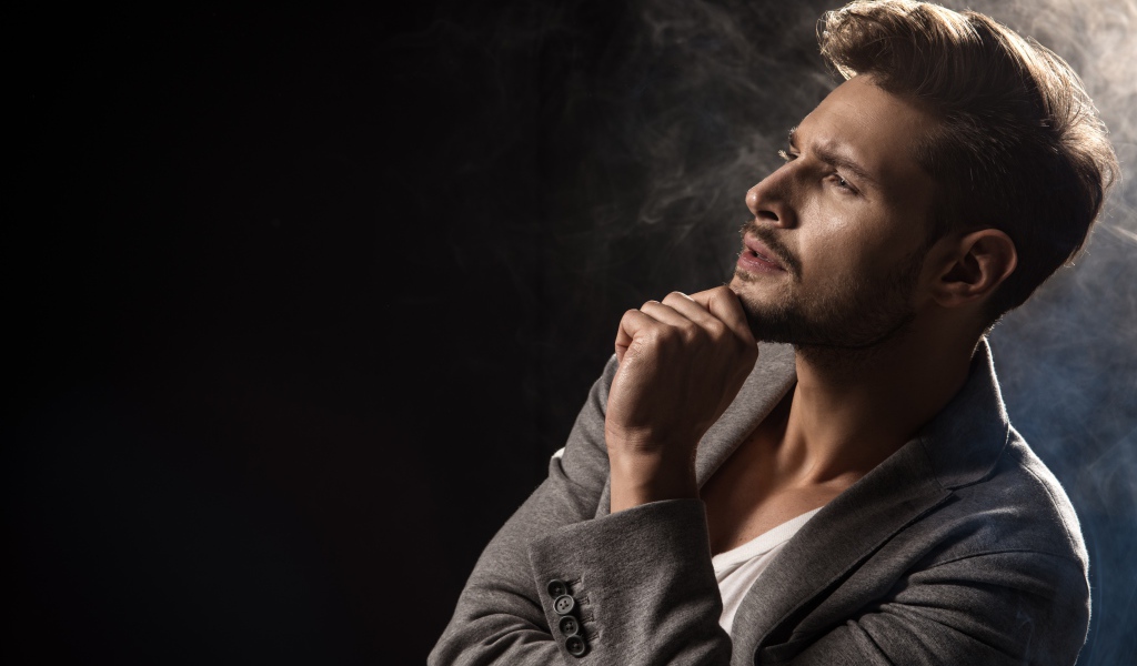 Задумчивый взгляд мужчины на черном фоне 