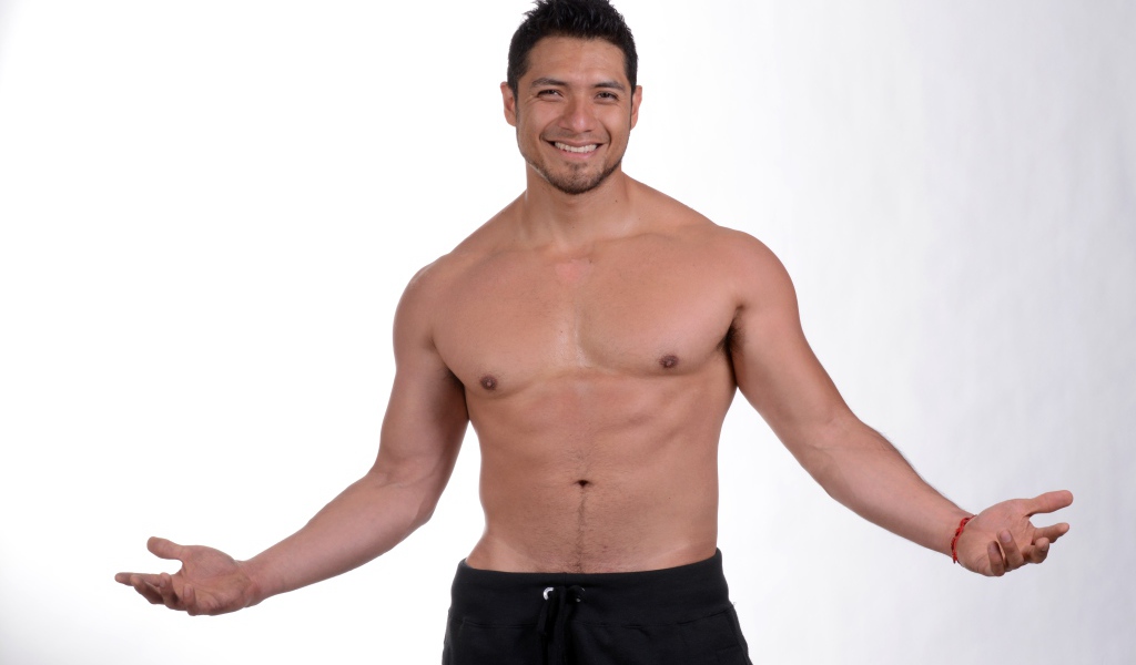 Улыбающийся накаченный мужчина на сером фоне