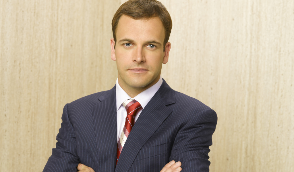 Актер Джонни Ли Миллер в костюме у стены