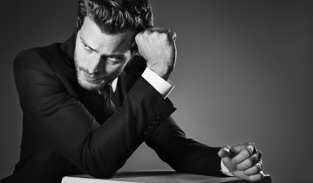 Британский актер Джейми Дорнан на сером фоне