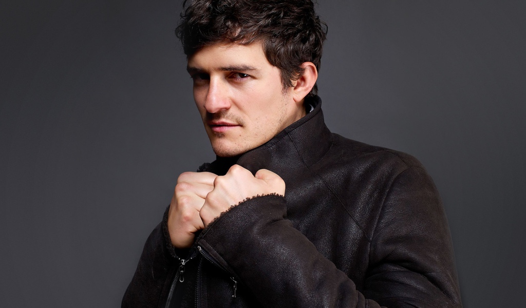 Красивый актер Орландо Блум на сером фоне