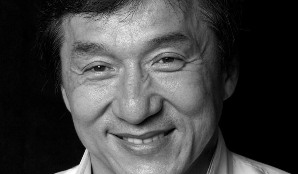 Лицо актера Джеки Чана на черном фоне