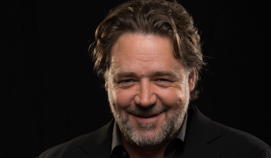 Улыбающийся Рассел Кроу на черном фоне