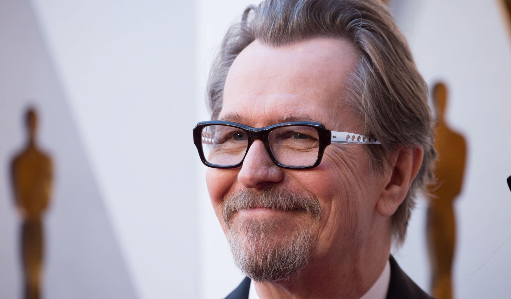 Улыбающийся мужчина, актер Гари Олдман в очках