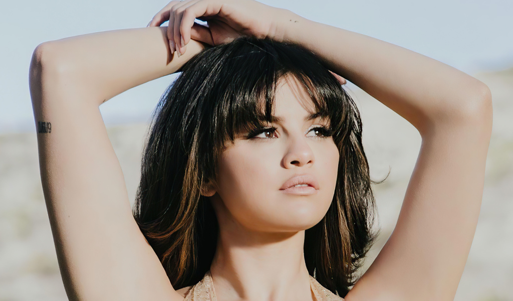 Американская певица Селена Гомес в поднятыми руками