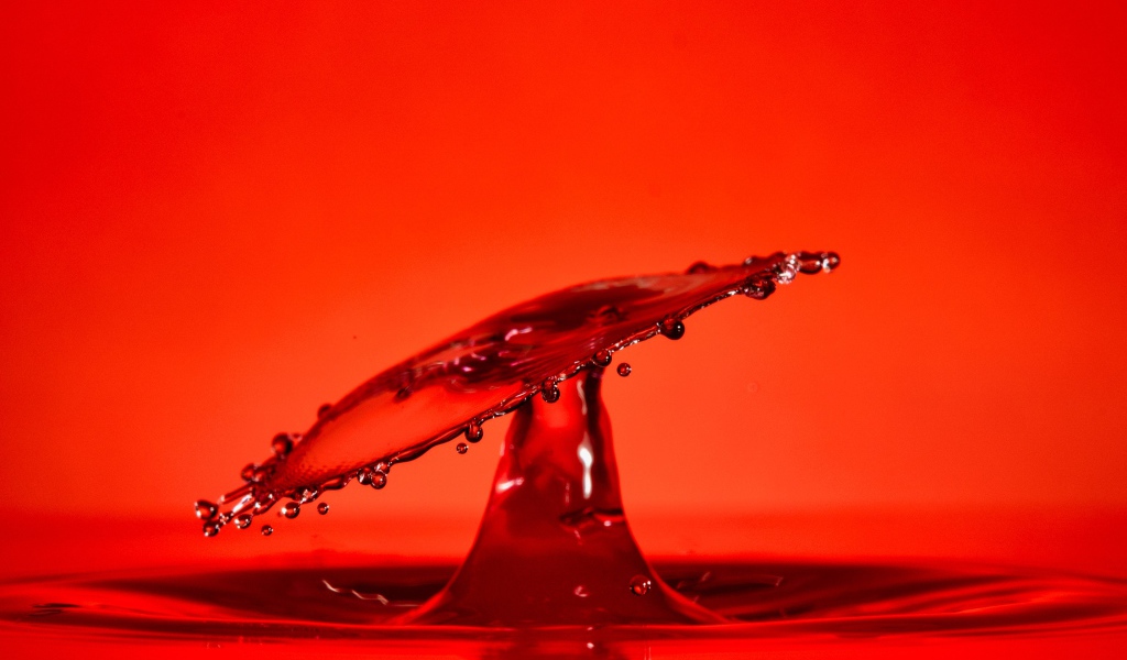 Брызги воды на красном фоне