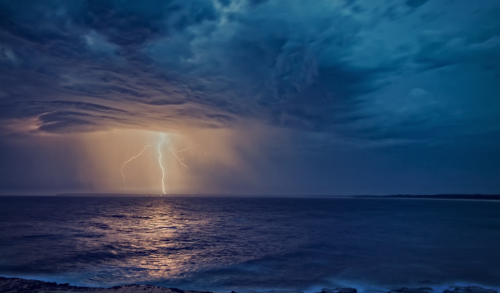 Белая молния рассекает небо в море 