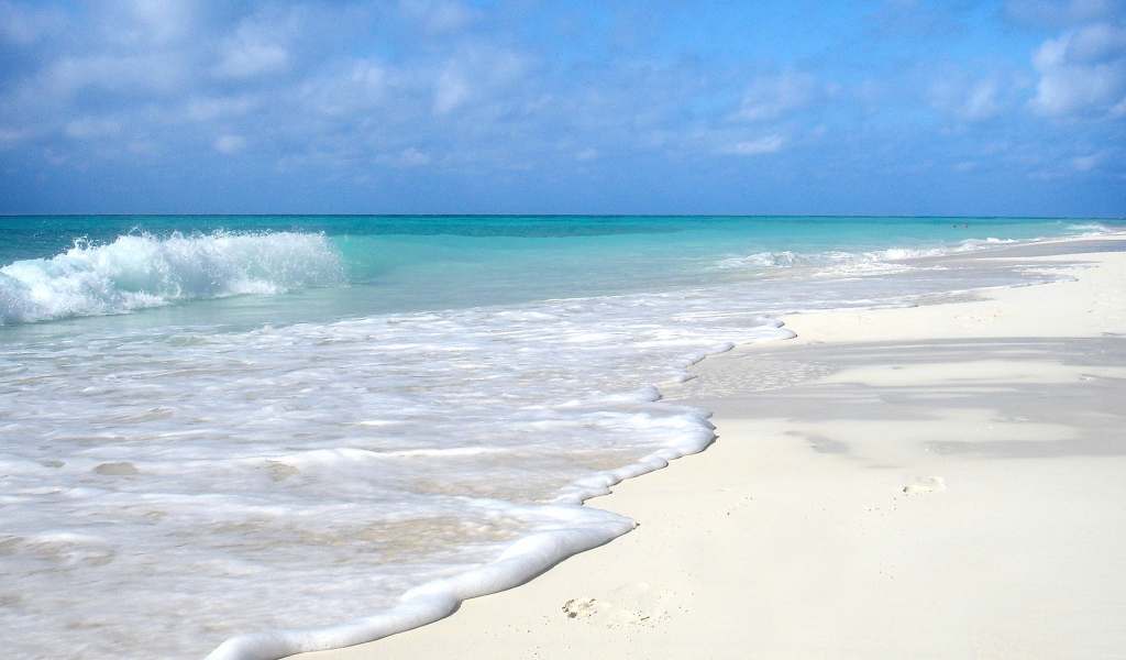 Чистый белый песок на пляже с голубой водой