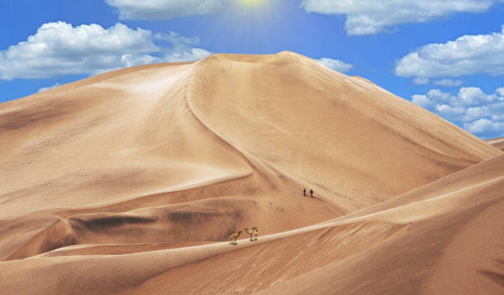 Высокая песчаная дюна под голубым небом 