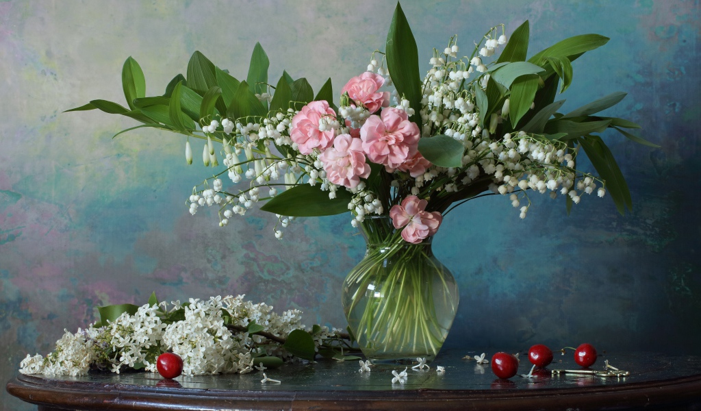 Красивый букет ландышей с розовыми цветами на столе с веткой сирени 