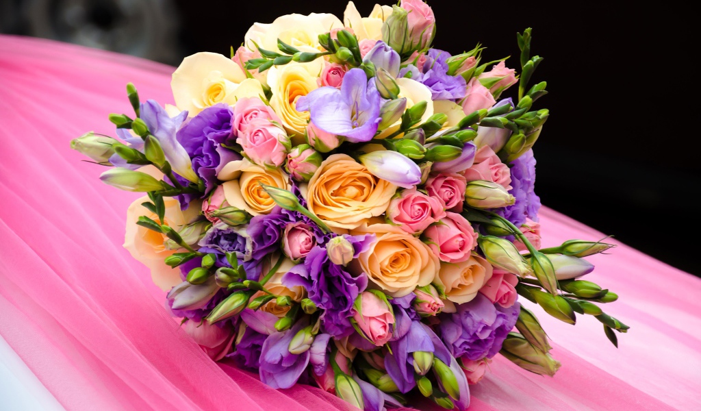 Красивый свадебный букет лежит на розовой ткани