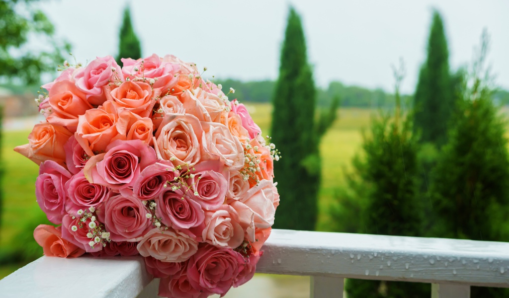 Красивый свадебный букет розовых роз на белых перилах