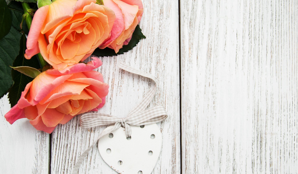 Три оранжевых цветка розы на сером столе