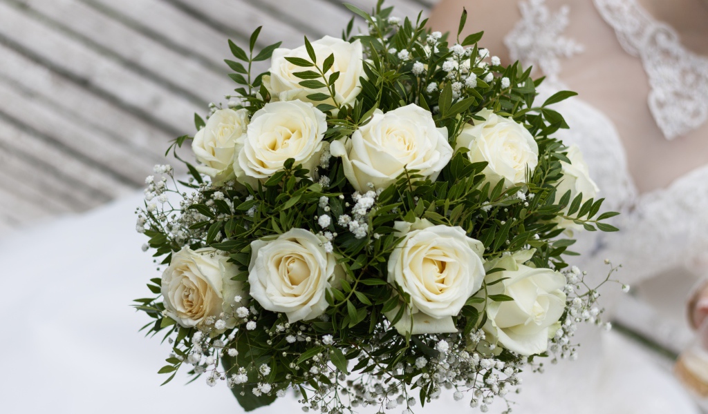 Свадебный букет белых роз в руке у невесты