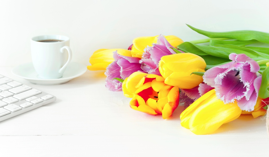 Желтые и розовые тюльпаны на столе с кофе