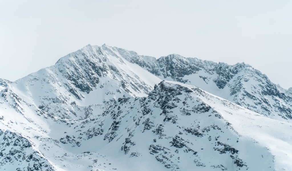 Заснеженная гора под серым небом 