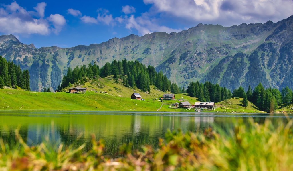 Красивый пейзаж на горы и озеро и зеленые луга