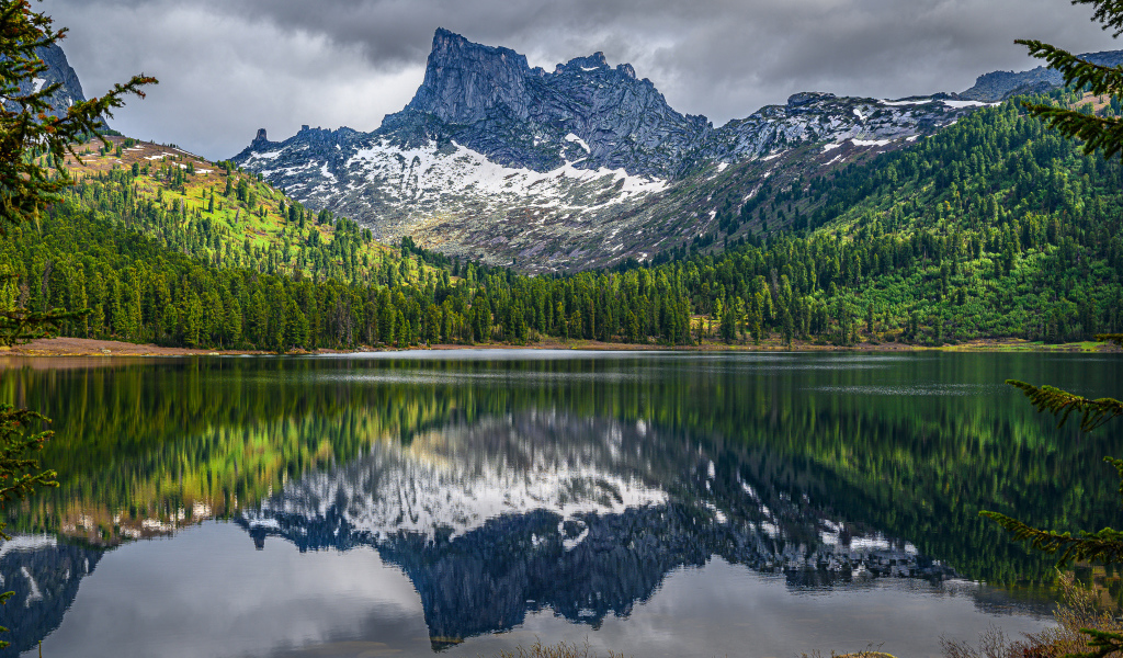 Красивая гора под грозовым небом отражается в озере 