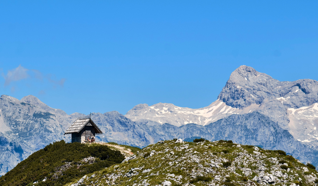 Дом на вершине горы под голубым небом