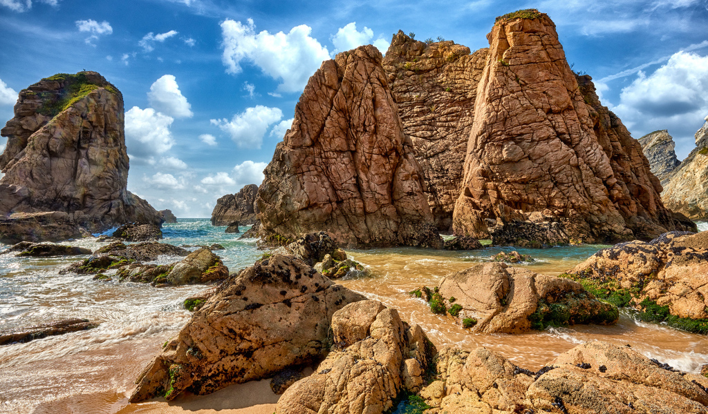 Большие каменные возвышенности в море под голубым небом 