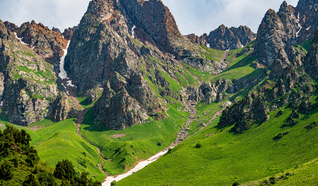 Большие каменные горы с зеленым ковром травы