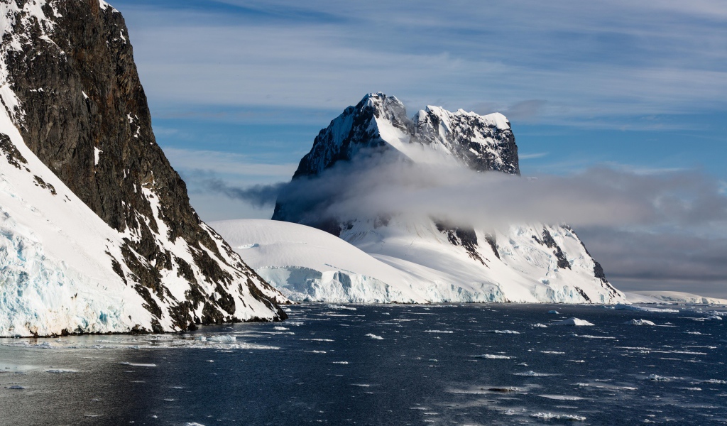 Заснеженные горы у покрытого льдом океана 