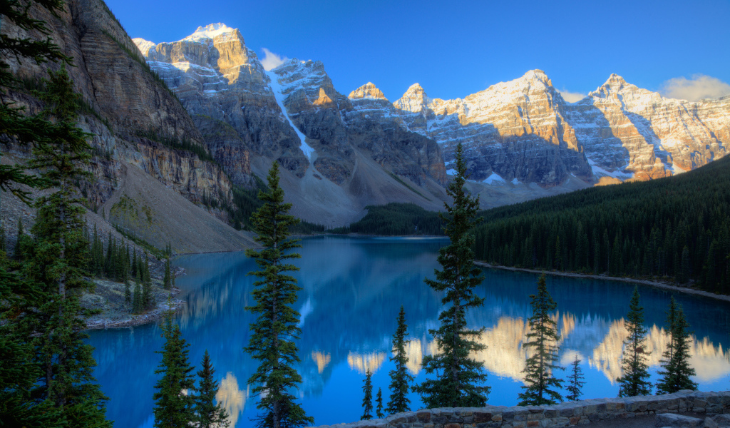 Каменные горы с заснеженными вершинами у озера 