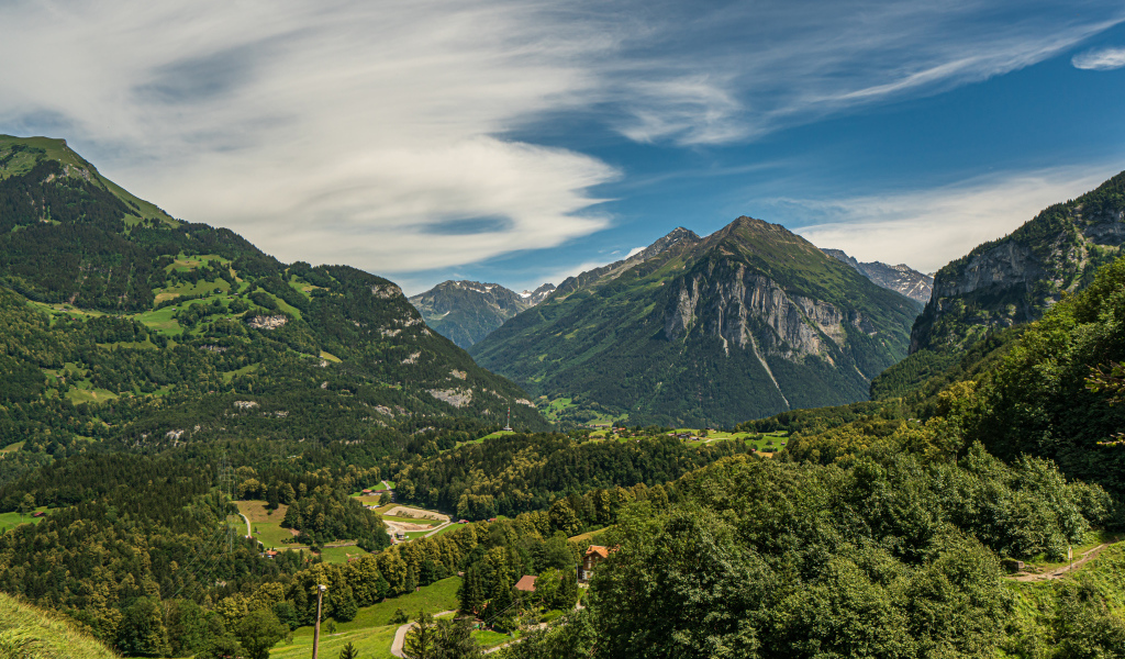 Высокие покрытые зеленью альпы под красивым небом, Швейцария 