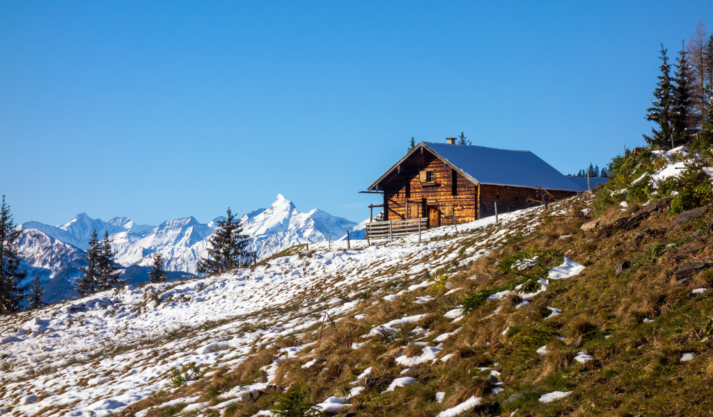 Деревянный дом на заснеженном склоне Альп