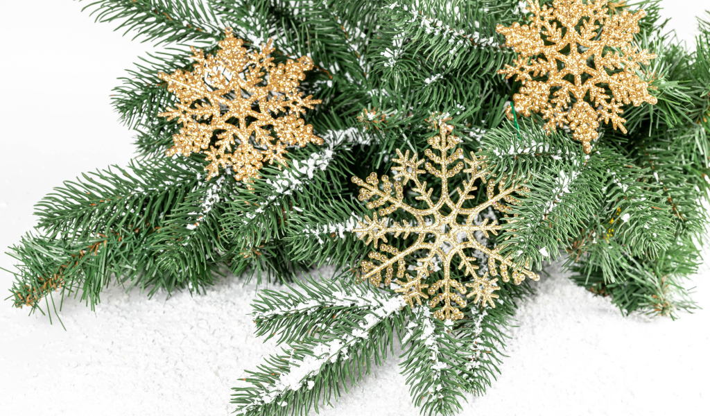 Золотистые снежинки и еловые ветки на снегу