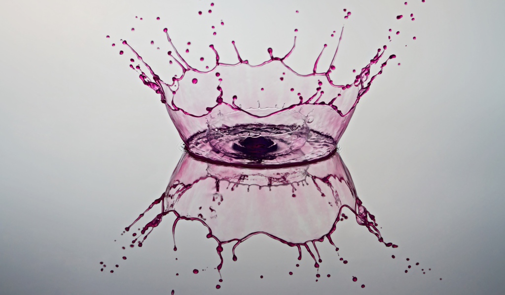 Брызги фиолетовой краски на сером фоне 