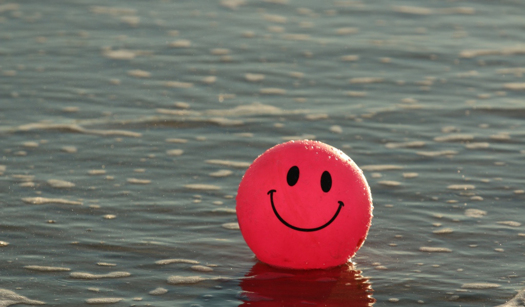 Красный мяч смайлик в воде 