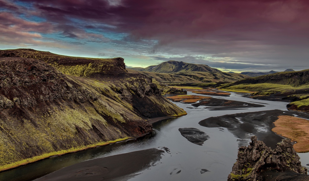 Неглубокая река среди зеленых гор