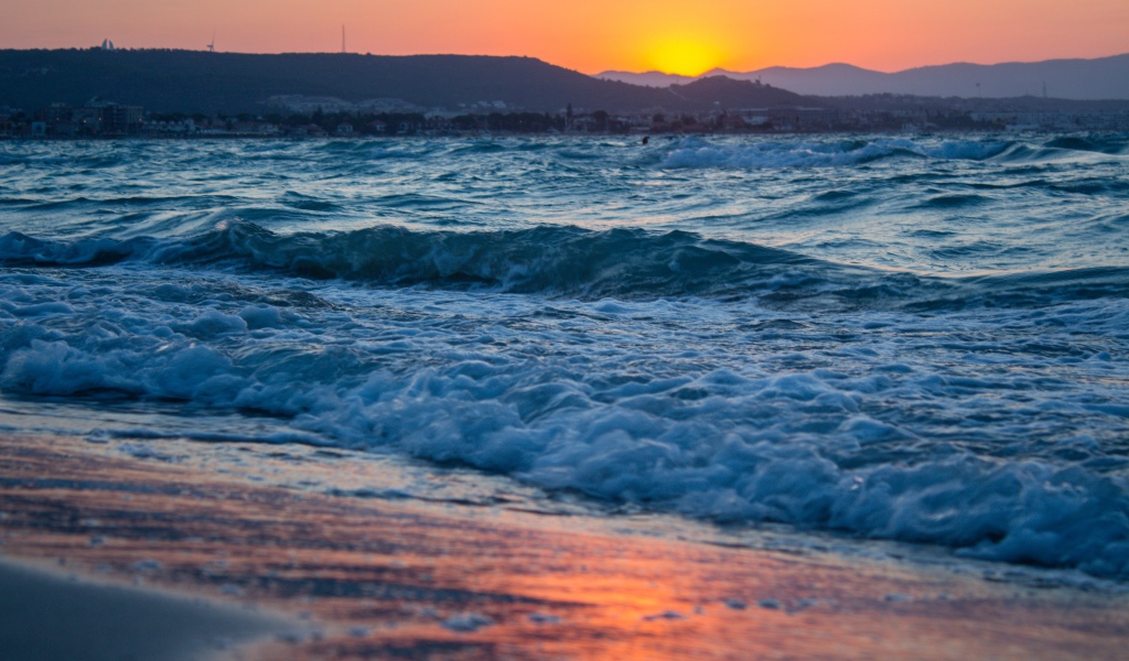 Бушующие волны на берегу моря на закате 