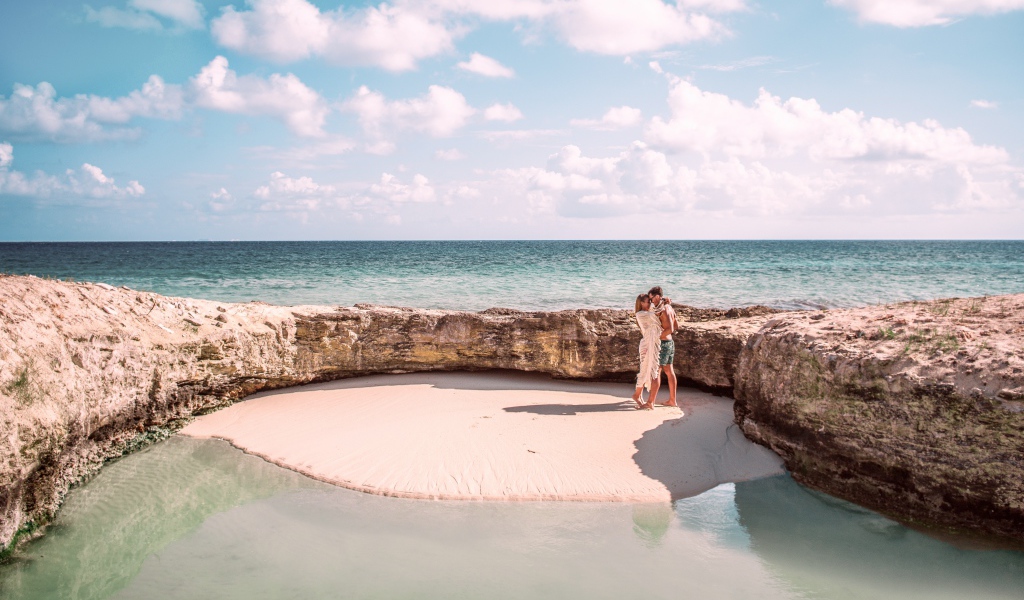 Каменное ограждение на морском пляже летом 