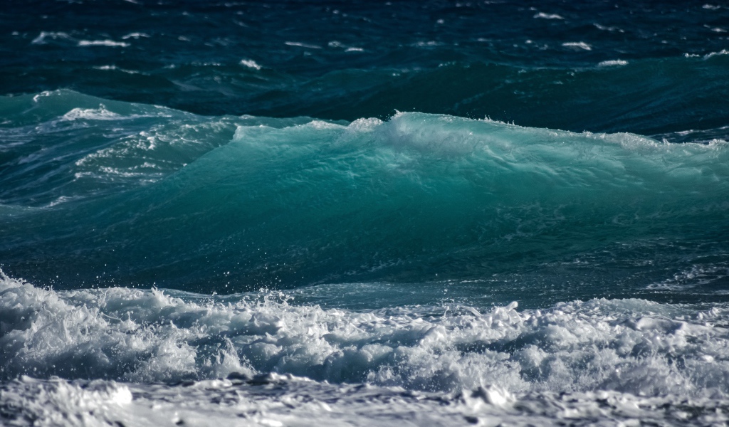 Волны с белой пеной поднимаются в море