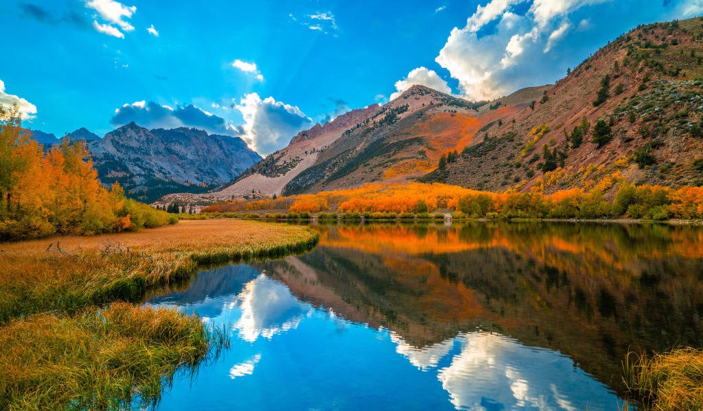 Красивый осенний горный пейзаж под голубым небом у  озера