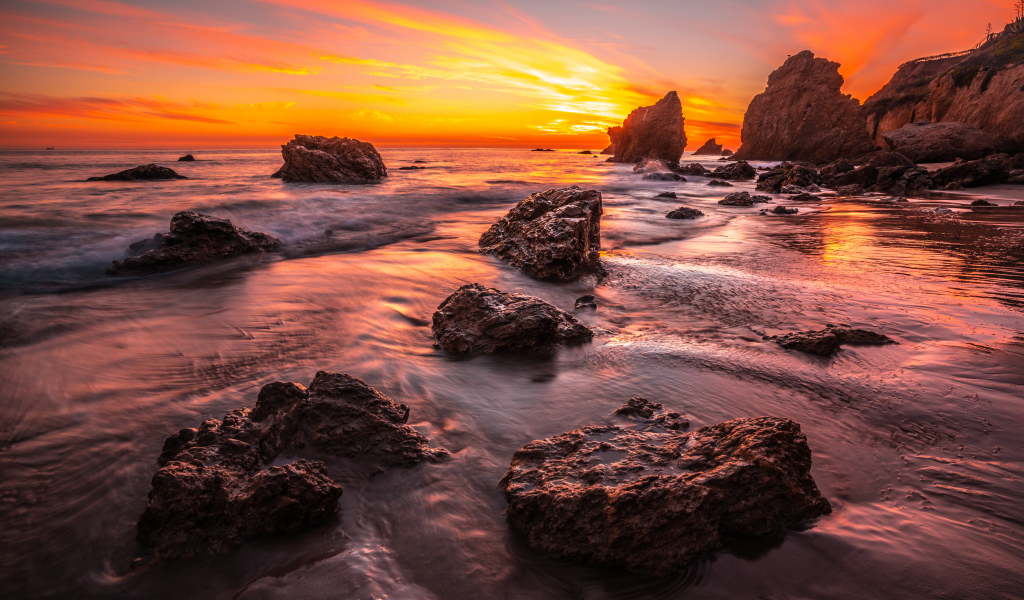 Красивый закат солнца на берегу моря с камнями 