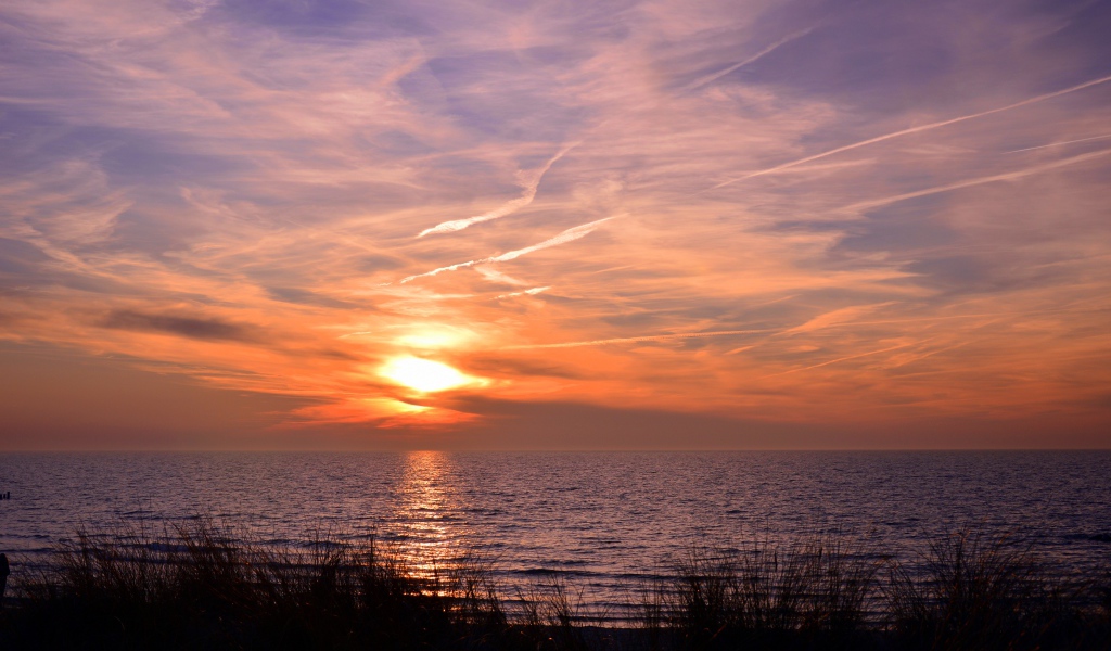 Закат солнца над спокойным озером летом