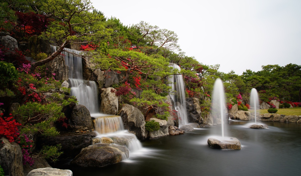 Водопады в красивом саду с зелеными деревьями