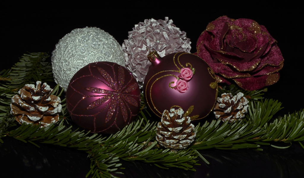 Красивые елочные игрушки с веткой на черном фоне 