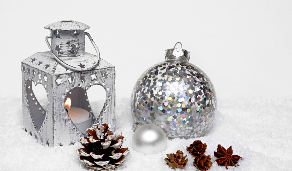 Фонарик и елочный шар с шишками на снегу