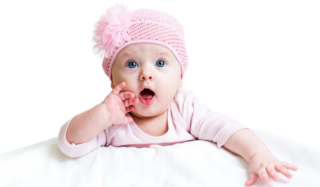 Красивая голубоглазая малышка в розовой шапке на белом фоне